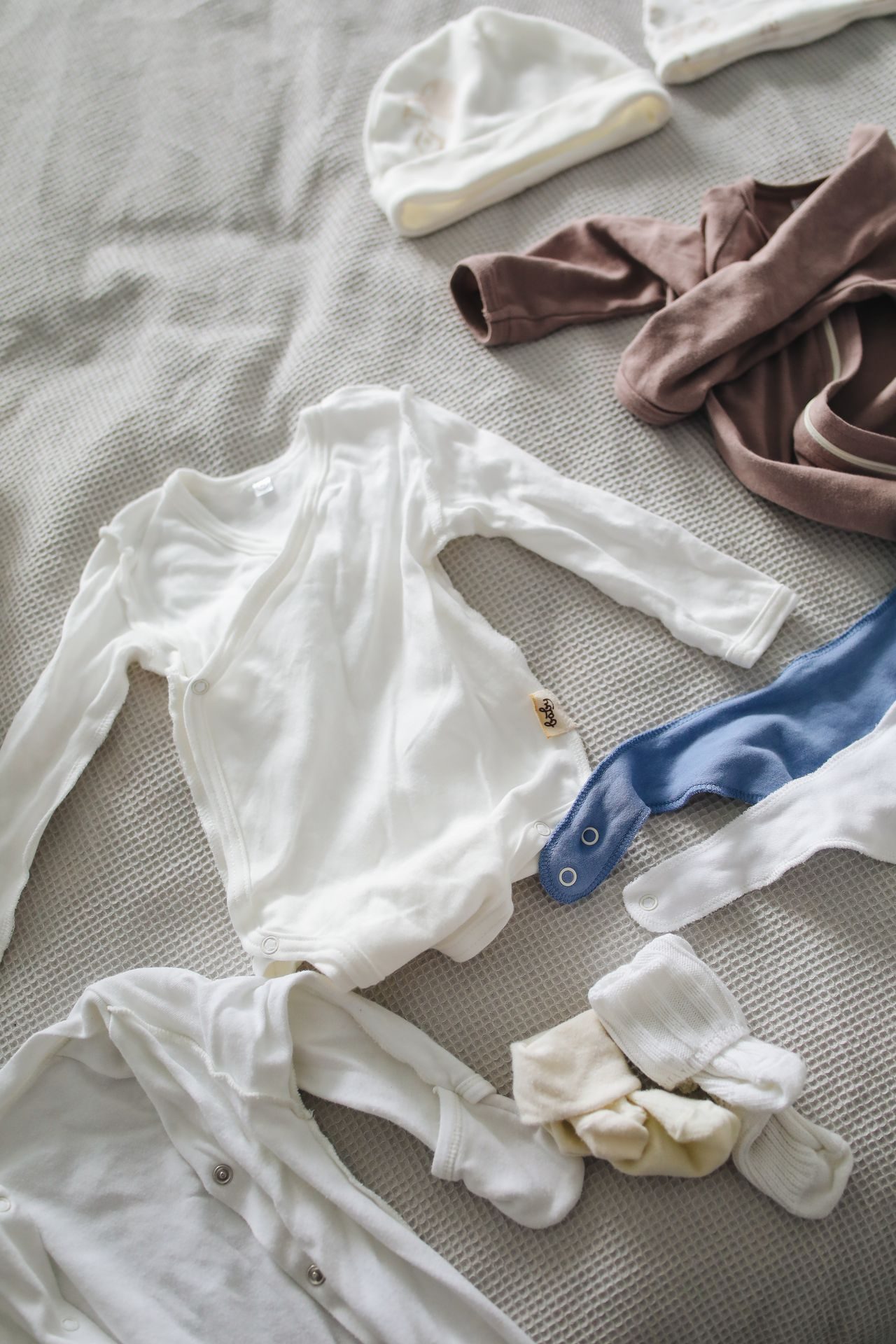 Small baby clothes and accessories laid out together