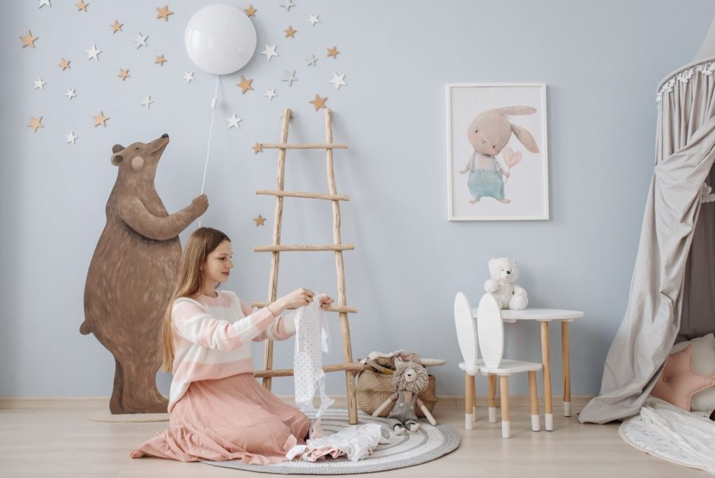 An adult organising small clothes in a nursery